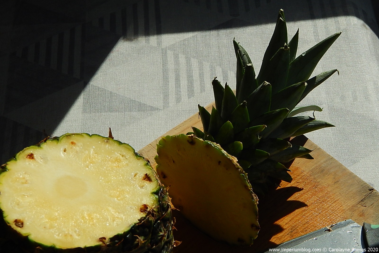 registo de um abacaxi, cortado pelo topo. evidente, o seu interior amarelo, iluminado pela luz solar.